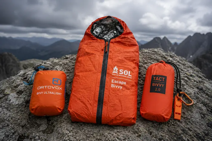 Porovnanie núdzových bivakov Ortovox Bivy Ultralight, SOL Escape Bivvy a Tact Bivvy 2.0 na horskom teréne.webp